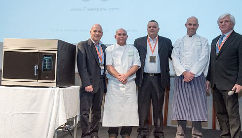 שמואל ברקן (מימין) מציג בכנס את התנור המהפכני ואת צוות הפיתוח