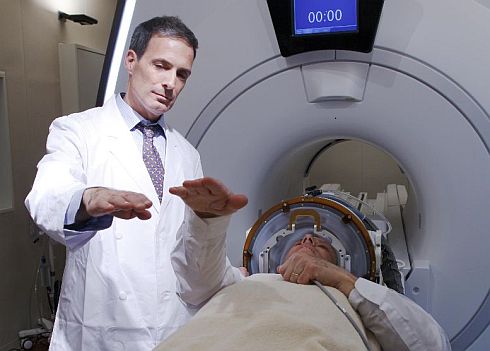 חולה בטיפול במכשיר MRI ביחד עם קסדת האולטרא סאונד של אינסייטק